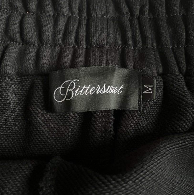 The woven satin label sewn into the back waistband, Bittersweet embroidered in script, size M beside it.